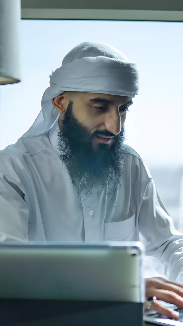 Ustadh Hudaifa Jawad working at a laptop