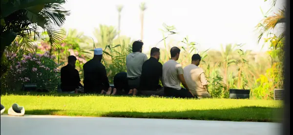 Brothers sitting together on a lawn at sunset